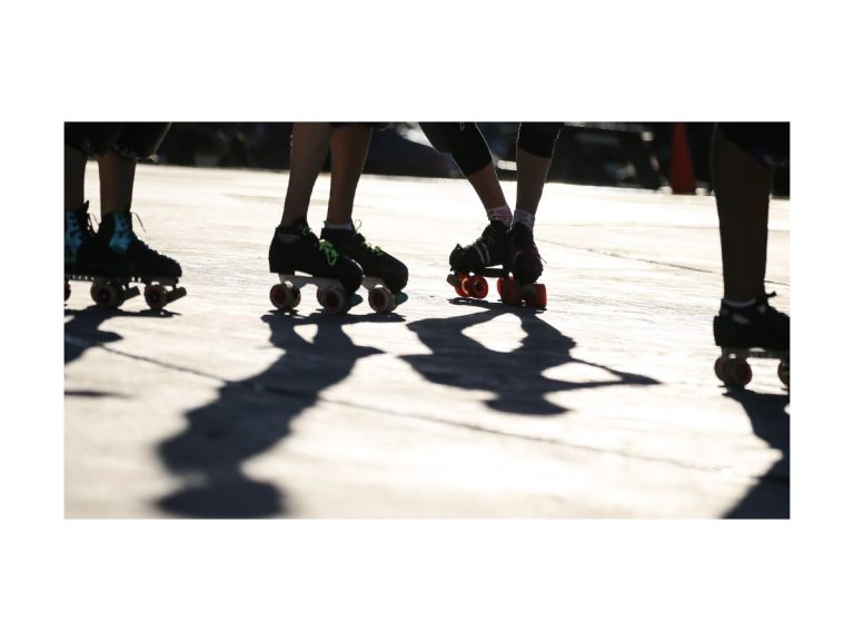 outdoor photo of roller skaters legs and skates, bright sunshine